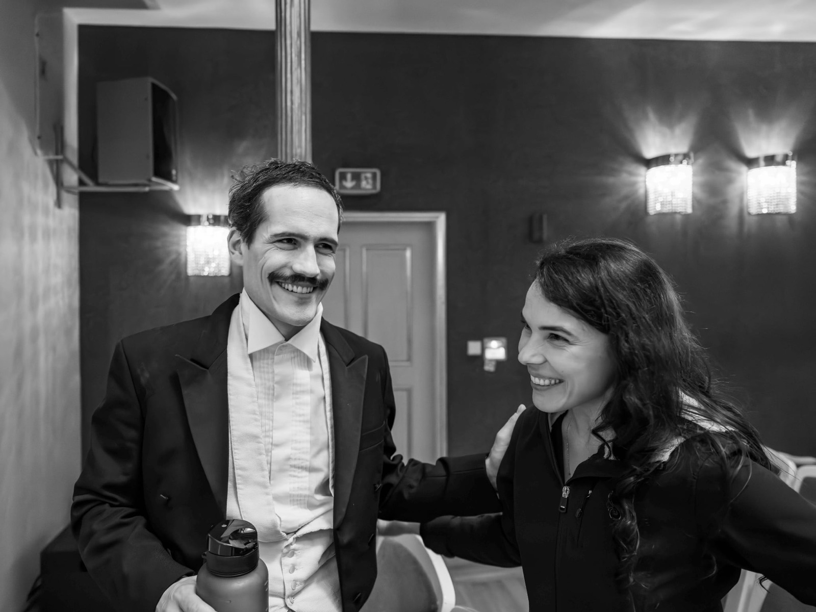 Petra Rațiu lacht hinter der Bühne mit einem Schauspieler im Clownskostüm