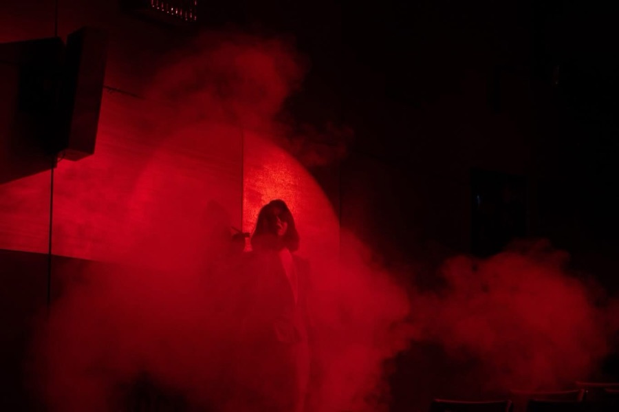 A lone figure in a cloud of red smoke.