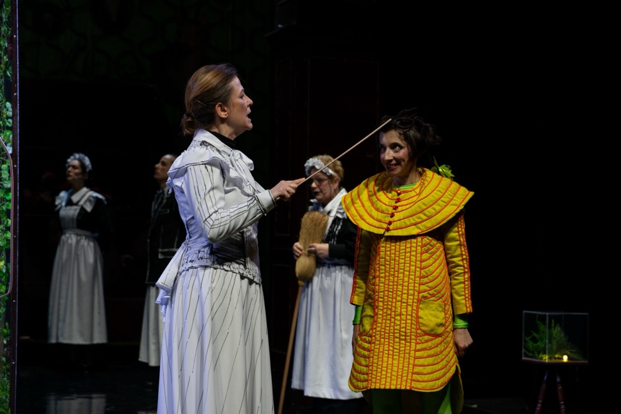 Miss Rottenmeier points a stick at Heidi while the staff watch.