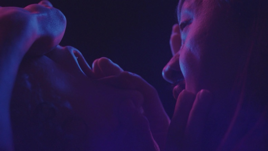 Fingers press into a cheek, the second face watching closely.